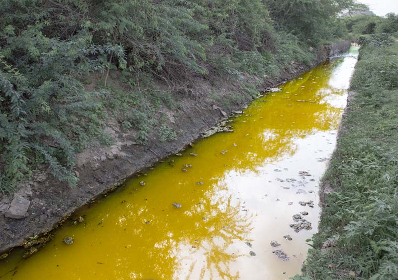 Industry and Violation of Human Right to Water - Colored effluent from Debari zinc smelter, in Udaipur district, Rajasthan, flowing through an irrigation canal in Bichhadi